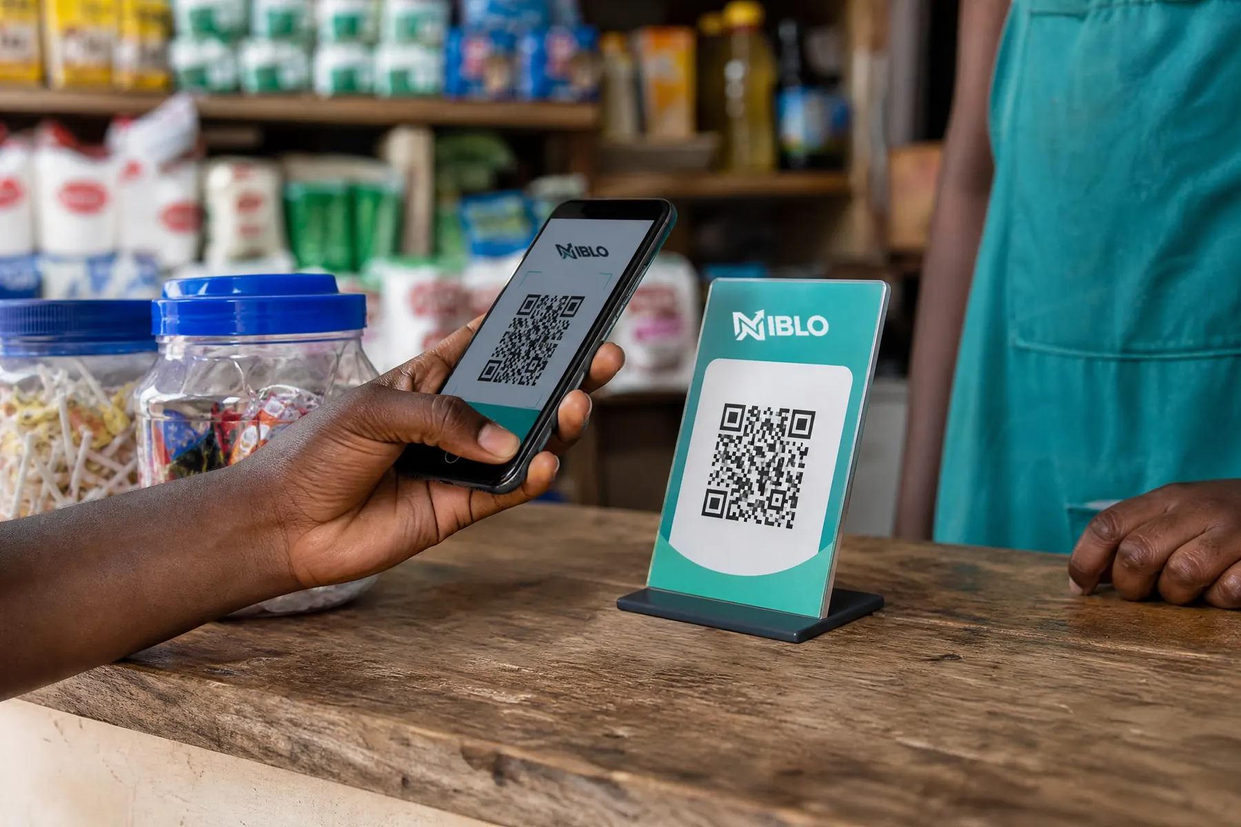 A customer paying with her phone at a shop counter while the shopkeeper waits